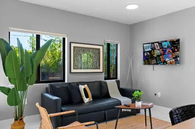 a living room with a black couch and a table at Urban Comfort - 20min to Beach & Airport in Miami