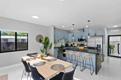 a kitchen and dining room with a table and chairs at Urban Comfort - 20min to Beach & Airport in Miami