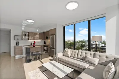 a living room with a couch and a kitchen at Luxury Pent House with Downtown Views in Miami