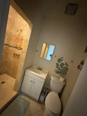 a bathroom with a toilet and a shower and a sink at Casa Rosa Wynwood in Miami