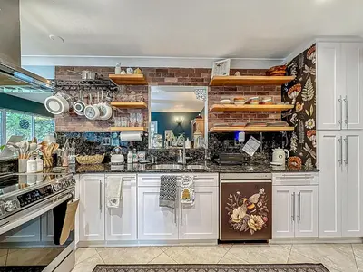 a large kitchen with white cabinets and appliances at Boho Oasis -World Cup base- under 20 min to stadium & FLL airport in Fort Lauderdale