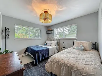 a bedroom with a bed and a chandelier at Boho Oasis -World Cup base- under 20 min to stadium & FLL airport in Fort Lauderdale