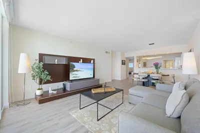 a living room with a couch and a tv at Golden Bay 504 in Sunny Isles Beach