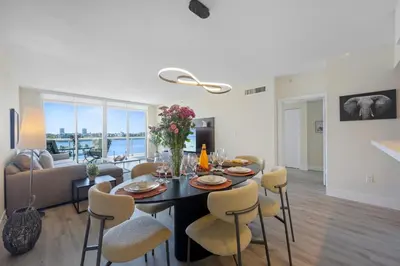 a dining room and living room with a table and chairs at Golden Bay 504 in Sunny Isles Beach