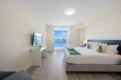 a bedroom with a large bed and a television at Golden Bay 504 in Sunny Isles Beach