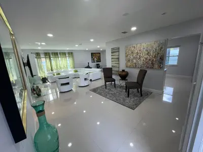 a living room with a couch and a table and chairs at Spacious 4BR Home 5 Min from Hard Rock Stadium in Miami Gardens