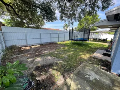 a backyard with a fence and a basketball hoop at Spacious 4BR Home 5 Min from Hard Rock Stadium in Miami Gardens