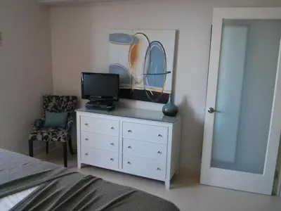 a bedroom with a white dresser with a television on it at 2 bedroom at The Roney Palace Condominiums Apt 1006 in Miami Beach