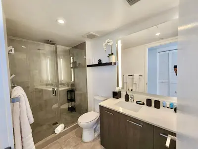 a bathroom with a shower and a toilet and a sink at Electric Luxury Downtown Bayfront Brickell in Miami