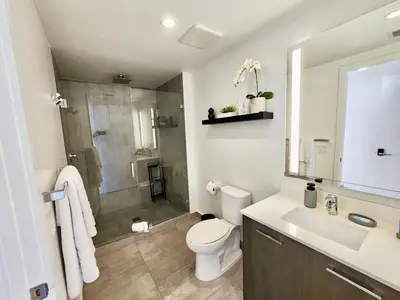 a bathroom with a shower and a toilet and a sink at Electric Luxury Downtown Bayfront Brickell in Miami