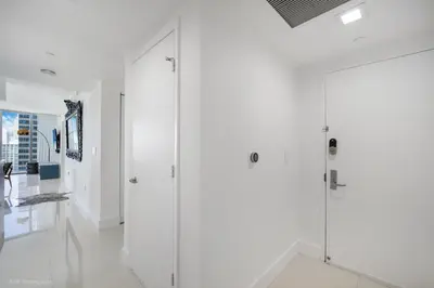 a bathroom with white walls and glass doors at Sublime Ocean & Pool View Unit At Icon Brickell in Miami