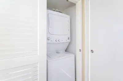 a white laundry room with a washer and dryer at Elegant Beachfront Retreat in Hollywood