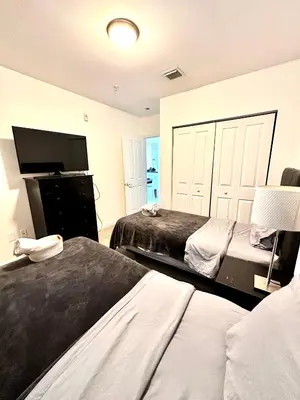 a bedroom with two beds and a flat screen tv at 202 Private bedroom in Miami - Coral Gables in Miami