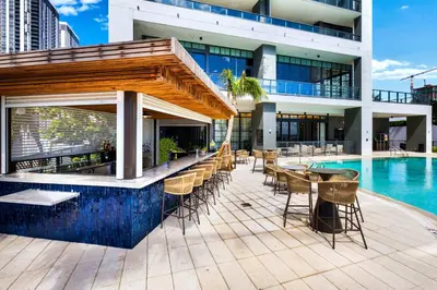 a building with a swimming pool and a patio with tables and chairs at Gale Hotel - Premium Studio W Panoramic City Views in Miami