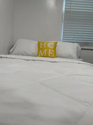 a white bed with a yellow pillow on it at El Rincon De Tati in Miami