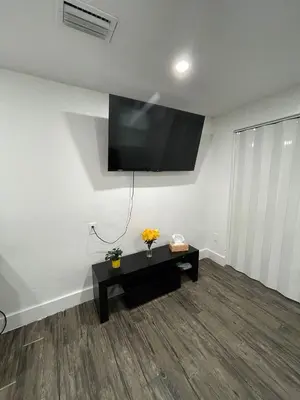 a living room with a flat screen tv on the wall at El Rincon De Tati in Miami