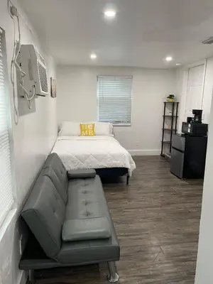 a bedroom with a bed and a couch in it at El Rincon De Tati in Miami