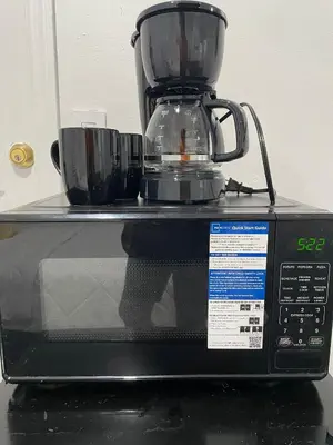 a coffee maker sitting on top of a microwave at El Rincon De Tati in Miami