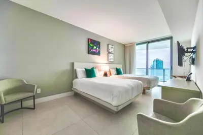 a hotel room with two beds and a chair at Charming Condo for Your Dream Vacation in Hollywood