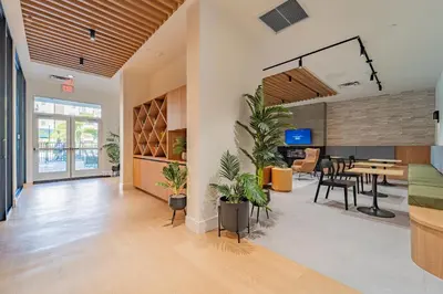 a living room with a table and chairs and a dining room at Devereaux Miami Luxury 2 Bedroom Apartment in Biscayne Gardens