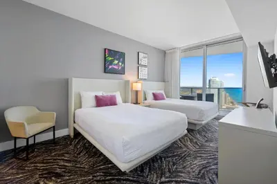a hotel room with two beds and a chair at Luxury 2BR Beachfront Rooftop Pool and Spa in Hollywood