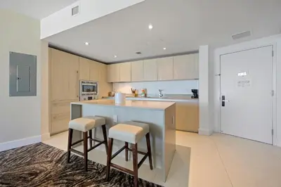 a kitchen with a counter and two stools at Luxury 2BR Beachfront Rooftop Pool and Spa in Hollywood