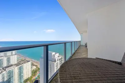 a balcony with a table and a view of the ocean at Luxury 2BR Beachfront Rooftop Pool and Spa in Hollywood