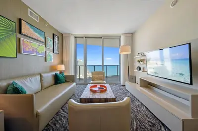 a living room with a couch and a tv at Luxury 2BR Beachfront Rooftop Pool and Spa in Hollywood