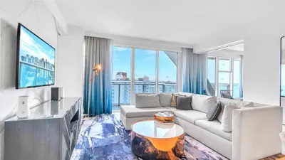 a living room with a couch and a tv at Exclusive Beachfront Condo at W Fort Lauderdale in Fort Lauderdale