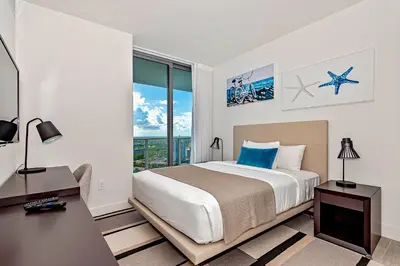 a bedroom with a bed and a desk and a window at Modern Condo Retreat with Ample Space in Hollywood