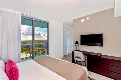a bedroom with a bed and a desk with a television at Modern Condo Retreat with Ample Space in Hollywood