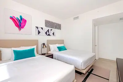 two beds in a room with white and blue at Modern Condo Retreat with Ample Space in Hollywood