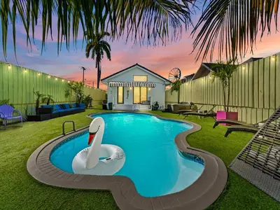 a swimming pool with a swan in the middle of a yard at The Velvet Palm Midtown Pool and Hot Tub in Miami