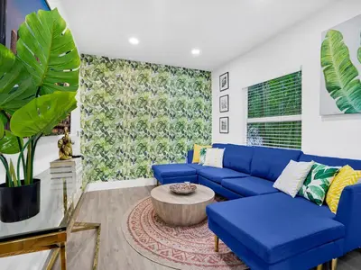 a living room with a blue couch and a coffee table at Bungalow House 6 BR Pool Little Havana in Miami