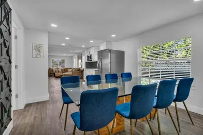 a dining room with a table and blue chairs at La Pergola Villa 7 BR PoolHot Tub Location in Miami