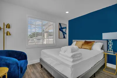 a blue and white bedroom with a bed and a chair at La Pergola Villa 7 BR PoolHot Tub Location in Miami
