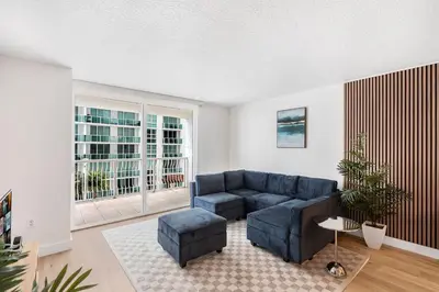 a living room with a blue couch and a large window at Enjoy Pool and Stunning City Views in Brickell in Miami