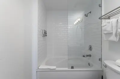 a white bathroom with a tub and a sink at Sunset Suite Skyline Views King and Twin Sofa Includes Parking in Miami
