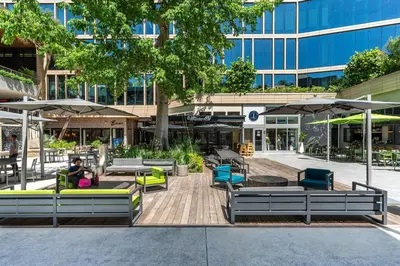 a courtyard with chairs and umbrellas in front of a building at Sunset Suite Skyline Views King and Twin Sofa Includes Parking in Miami