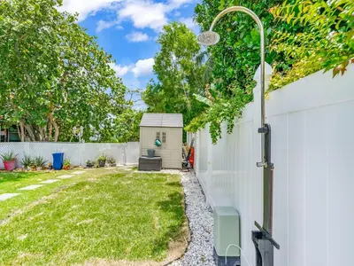 a backyard with a white fence and a shed at Canal Views from Pool w BBQ and Pit Miami Escape in Kendale Lakes