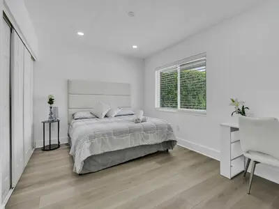 a white bedroom with a bed and a window at Canal Views from Pool w BBQ and Pit Miami Escape in Kendale Lakes