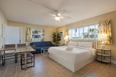 a bedroom with a bed and a table and a couch at Coconut Bay Resort in Fort Lauderdale