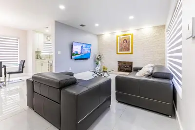 a living room with two leather couches and a tv at Stylish 3BR Home - BBQ & Near Top Attractions in Miami Gardens