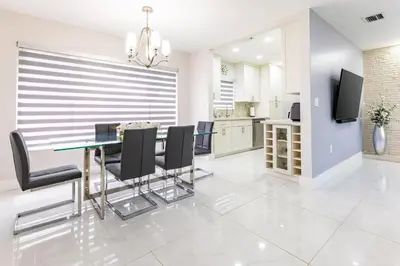 a dining room with a glass table and black chairs at Stylish 3BR Home - BBQ & Near Top Attractions in Miami Gardens