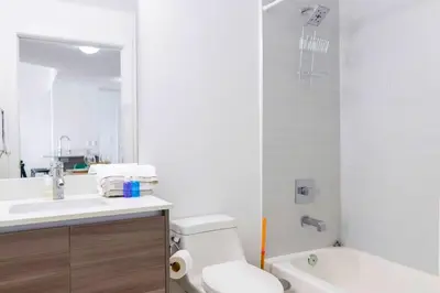 a bathroom with a toilet and a sink and a tub at Contemporary Condo in Wynwood w Free Parking in Miami
