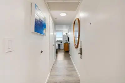 a hallway of a house with white walls and wooden floors at Elegant 2BR Condo at Hotel Arya Full Kitchen Wraparound Views 2 Parking Spots in Miami