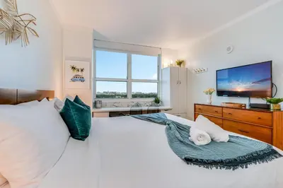 a bedroom with a large white bed with a large window at Elegant 2BR Condo at Hotel Arya Full Kitchen Wraparound Views 2 Parking Spots in Miami