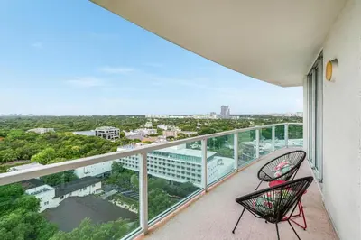 two chairs on a balcony with a view of a city at Elegant 2BR Condo at Hotel Arya Full Kitchen Wraparound Views 2 Parking Spots in Miami