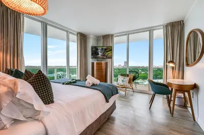 a bedroom with a large bed and large windows at Modern 3BR 3BA Grove Condo Views Balconies Full Kitchen 3 Parking in Miami