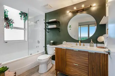 a bathroom with a toilet and a mirror at Modern 3BR 3BA Grove Condo Views Balconies Full Kitchen 3 Parking in Miami